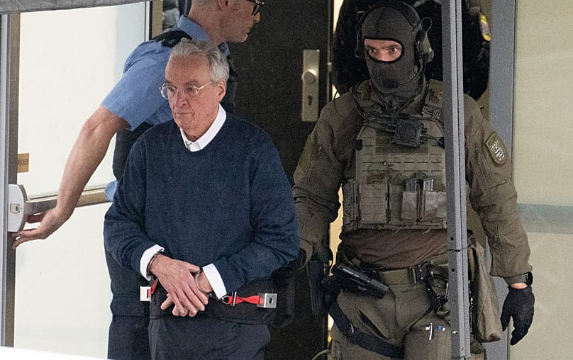 The main defendant Heinrich XIII Prince Reuss, front left, is lead off a temporary courtroom that was built for a trial starting on Tuesday in Frankfurt, Germany, May 21, 2024