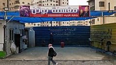 Eine Palästinenserin geht in Ramallah an einem Schild mit dem Bild des russischen Präsidenten Wladimir Putin vorbei, „Putins Autowäsche“, 23. Februar 2026.