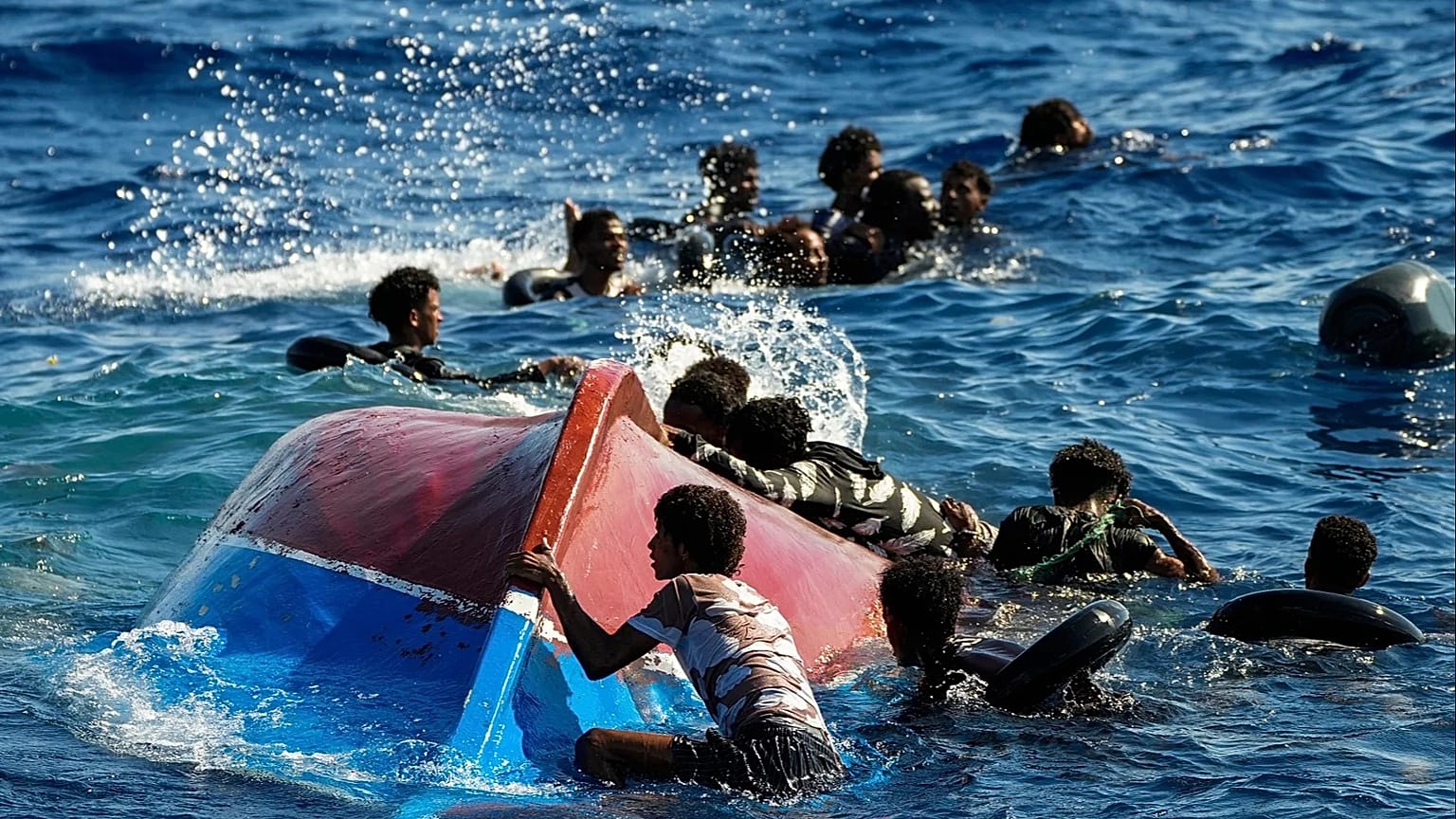 Migrants in a wooden boat call for help as they are assisted during a rescue operation south of the Italian island of Lampedusa, 11 August, 2022