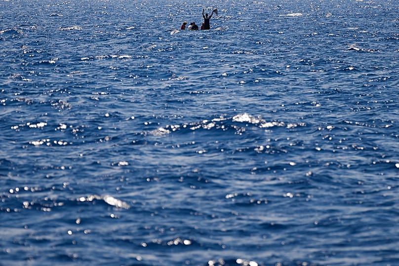 Migrants in a wooden boat call for help as they are assisted during a rescue operation south of the Italian island of Lampedusa, 11 August, 2022