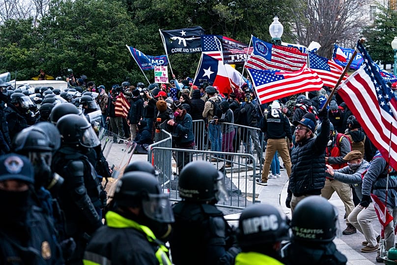 Supporters of President Donald Trump are confronted by US Capitol Police officers outside the Capitol, 6 January, 2021