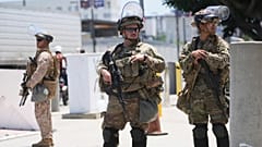 عناصر من الحرس الوطني في كاليفورنيا ومشاة البحرية الأمريكية يحرسون مبنى فيدرالياً في لوس أنجلوس، 17 يونيو 2025.