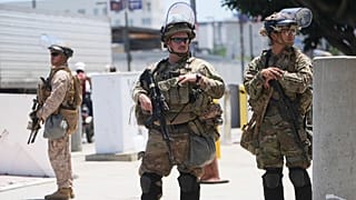 عناصر من الحرس الوطني في كاليفورنيا ومشاة البحرية الأمريكية يحرسون مبنى فيدرالياً في لوس أنجلوس، 17 يونيو 2025.