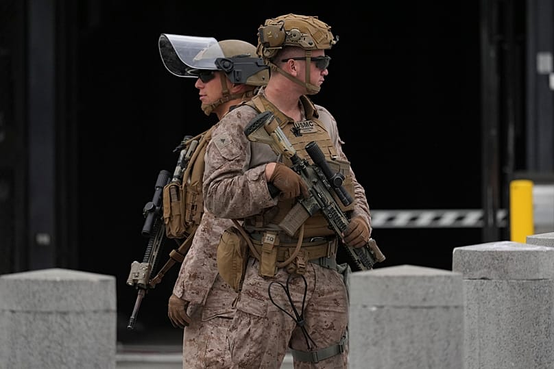 عناصر من الحرس الوطني في كاليفورنيا ومشاة البحرية الأمريكية يحرسون مبنى فيدرالياً في لوس أنجلوس، 17 يونيو 2025.