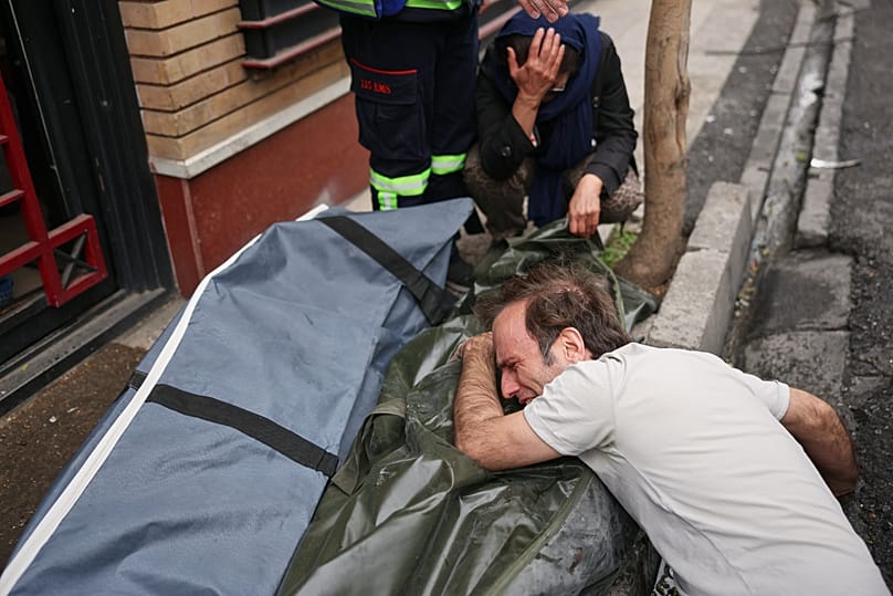 مردی در حالی که پیکر یکی از عزیزانش را در آغوش گرفته است، گریه می‌کند، حمله به مناطق مسکونی در تهران، ۲۸ مارس ۲۰۲۶