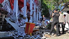 Polizisten untersuchen ein beschädigtes Gebäude nach einem Erdbeben in Manado auf Nordsulawesi.