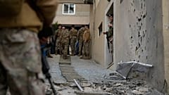 Soldaten der libanesischen Armee sehen eine beschädigte Mauer, nachdem abgefangene Raketen an der Küste von Alma, nördlich von Beirut, Libanon, gelandet sind, Dienstag, 24. März 2026.