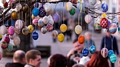 ARCHIV - Besucher fotografieren hinter einem Baum mit mehr als 10.000 bemalten Ostereiern in Saalfeld in der Mitte Deutschlands, 30. März 2018.