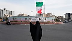 امرأة تلوح بالعلم الإيراني خلال حملة لدعم الحكومة في ساحة الثورة الإسلامية، في وسط مدينة طهران، إيران، الأحد 22 مارس 2026.