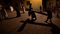 Unos fieles portan una cruz a modo de penitencia.