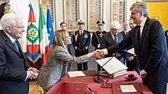 La premier Giorgia Meloni e il ministro del Turismo Gianmarco Mazzi si stringono la mano alla presenza del presidente della Repubblica Sergio Mattarella