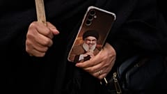 تحمل امرأة هاتفًا مزيّنًا بصورة الأمين العام الراحل لحزب الله السيد حسن نصرالله خلال احتجاج أمام السفارة الإيرانية، بيروت، لبنان، الخميس 26 مارس/آذار 2026. 