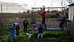 Kinder spielen in einem Hinterhof in dem befreiten Dorf Kyselivka, 15. November 2022 
