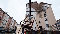 Menschen gehen vor einem Haus spazieren, das nach einem russischen Angriff auf ein Wohnviertel in Kriukivshchyna, Region Kiew, Ukraine, am Freitag, 3. April 2026, beschädigt wurde. 