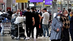 Reisende stehen am Flughafen Schlange, um ihren Flug zu erreichen