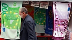 Ein Mann geht an einem Kiosk in der Athener Innenstadt vorbei. Dort werden Strandtücher verkauft, bedruckt wie Euro-Scheine mit hohem Nennwert, Freitag, 30. November 2012.