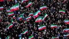 يلوح المشيعون بالأعلام الإيرانية في طهران، إيران، الأربعاء 1 أبريل/نيسان 2026، خلال موكب جنازة علي رضا تنجسيري، قائد القوات البحرية التابعة للحرس الثوري الإيراني، وآخرين قُتلو
