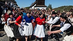 Junge Männer und Frauen in Tracht feiern das Osterbrauchtumsfest im Dorf Hollókő, einem UNESCO-Welterbe im Nordosten Ungarns.