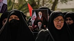 نساء عراقيات يحملن صورة المرشد الأعلى الإيراني الراحل آية الله علي خامنئي وابنه آية الله مجتبى خامنئي.
