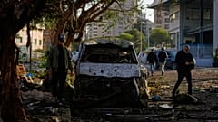 مارة يسيرون قرب مركبة متضررة عقب غارة إسرائيلية في بيروت، لبنان، في 1 أبريل 2026.