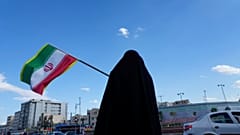 امرأة تلوّح بالعلم الإيراني خلال حملة لدعم الحكومة في ساحة انقلاب إسلامي، أو الثورة الإسلامية، في وسط مدينة طهران، إيران، يوم الاثنين 30 مارس 2026. 