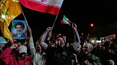 يهتف المتظاهرون المؤيدون للحكومة بشعارات وهم يحملون الأعلام الإيرانية وملصقًا للمرشد الأعلى آية الله مجتبى خامنئي في تجمع بعد الإعلان عن وقف إطلاق النار لمدة أسبوعين في الحرب 