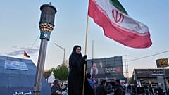 امرأة تحمل العلم الإيراني عند تقاطع في وسط مدينة طهران، إيران، الاثنين 6 أبريل 2026.