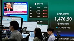 DATEI - US-Präsident Donald Trump ist auf einem Bildschirm zu sehen, während Händler im Devisenhandelsraum des Hauptsitzes der Hana Bank in Seoul arbeiten. 8. April 2025