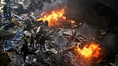 Ersthelfer und Freiwillige durchsuchen die Trümmer neben brennenden Autos am Ort eines israelischen Luftangriffs, der ein Wohnhaus in Beirut getroffen hat, 8. April 2026