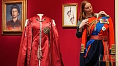Royal Collection Trust çalışanı, Kraliçe II. Elizabeth'in giydiği bir tören ceketini, tarzına adanmış Londra sergisi öncesinde inceliyor, 9 Nisan 2026