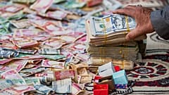 Gente dona dinero tras un llamamiento del Gran Ayatolá Ali al-Sistani para apoyar a Irán y Líbano durante la guerra, Babilonia, Irak, 27 de marzo de 2026.