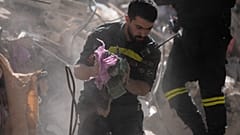 عامل إنقاذ يحمل أموالاً تم انتشالها من تحت أنقاض مبنى مدمر تعرض للقصف قبل يوم واحد في غارة جوية إسرائيلية وسط بيروت، لبنان، الخميس 9 أبريل 2026. 