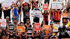 Demonstrierende halten Schilder hoch und fordern die Abgrenzung ihres Landes beim Marsch des Acampamento Terra Livre 2026.
