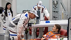 Die NASA-Astronautin Christina Koch, Spezialistin der Artemis-II-Mission, lässt ihren Raumanzug im Umkleideraum der Crew überprüfen.