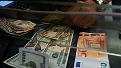 Eine Kassiererin tauscht an einer Wechselstube in Rom einen 50‑Euro-Schein in US-Dollar um, am Mittwoch, 13. Juli 2022.