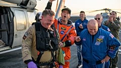 Astronaut Reid Wiseman klettert mit Hilfe von Crewmitgliedern vom Flugdeck der USS John P. Murtha, nachdem er aus dem Orion-Raumschiff geborgen wurde.