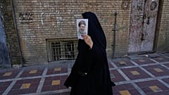 امرأة تحمل ملصقًا يصور المرشد الأعلى الإيراني آية الله مجتبى خامنئي بينما يتجمع أنصار الحكومة لإحياء الذكرى الأربعين لمقتل والده المرشد الأعلى آية الله علي خامنئي، في طهران