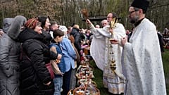 Priester segnen Gläubige und ihre Osterkörbe anlässlich des orthodoxen Osterfestes in Pyrohiv, in der Nähe von Kiew, Ukraine, Sonntag, 12. April 2026.