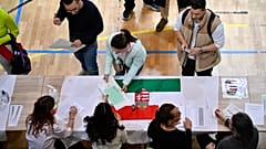 Una donna prende le schede elettorali in un seggio durante le elezioni parlamentari ungheresi a Budapest, in Ungheria, domenica 12 aprile 2026. (Foto AP/Denes Erdos)