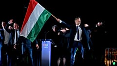 Peter Magyar, leader of the opposition Tisza party, waves the Hungarian flag following the announcement of the partial results of the parliamentary election, in Budapest, Hung