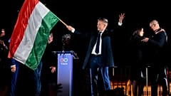Péter Magyar, líder del partido Tisza, agita la bandera húngara tras el anuncio de los resultados parciales de las elecciones legislativas en Hungría, el 12 de abril de 2026