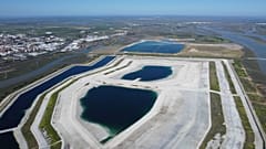 Ein Drohnenflug fängt giftige Abfälle ein, die nach den Winterregenfällen nur wenige Meter von der Stadt Huelva entfernt aus dem Untergrund aufsteigen (links).