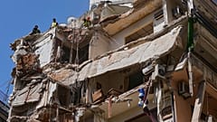 Workers remove the rubble as rescuers keep searching for a missing woman and girl at a destroyed building in Beirut, 13 April, 2026