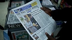 Ein Arbeiter posiert für Fotos mit einer Ausgabe des Wall Street Journal in London, 12. Oktober 2011