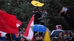 متظاهر يلوح بعلم حزب الله خلال احتجاج ضد رئيس الوزراء اللبناني نواف سلام، أمام القصر الحكومي في بيروت، لبنان، الجمعة 10 أبريل 2026. (صورة من وكالة أسوشيتد برس/إميليو موريناتي)