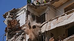 Arbeiter beseitigen die Trümmer, während Retter in einem zerstörten Gebäude in Beirut weiter nach einer vermissten Frau und einem Mädchen suchen, 13. April 2026