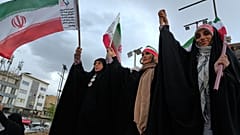 نساء يتكاتفن وهن يحملن الأعلام الإيرانية خلال حملة لدعم الحكومة في ساحة انقلاب الإسلامي، أو الثورة الإسلامية، في وسط مدينة طهران