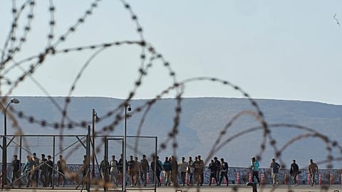 Migrants rescued south of Crete walk after their arrival at the port of Lavrio, 10 July, 2025