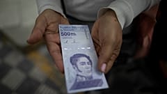 ARCHIVO - En esta foto de archivo del 16 de marzo de 2021, una mujer muestra un nuevo billete de 500.000 bolívares tras retirarlo de un banco en Caracas, Venezuela.