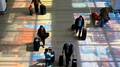 Buntglasfenster werfen bunte Schatten auf den Boden, wenn Reisende durch den New Yorker Flughafen LaGuardia laufen, Montag, 30. März 2026.